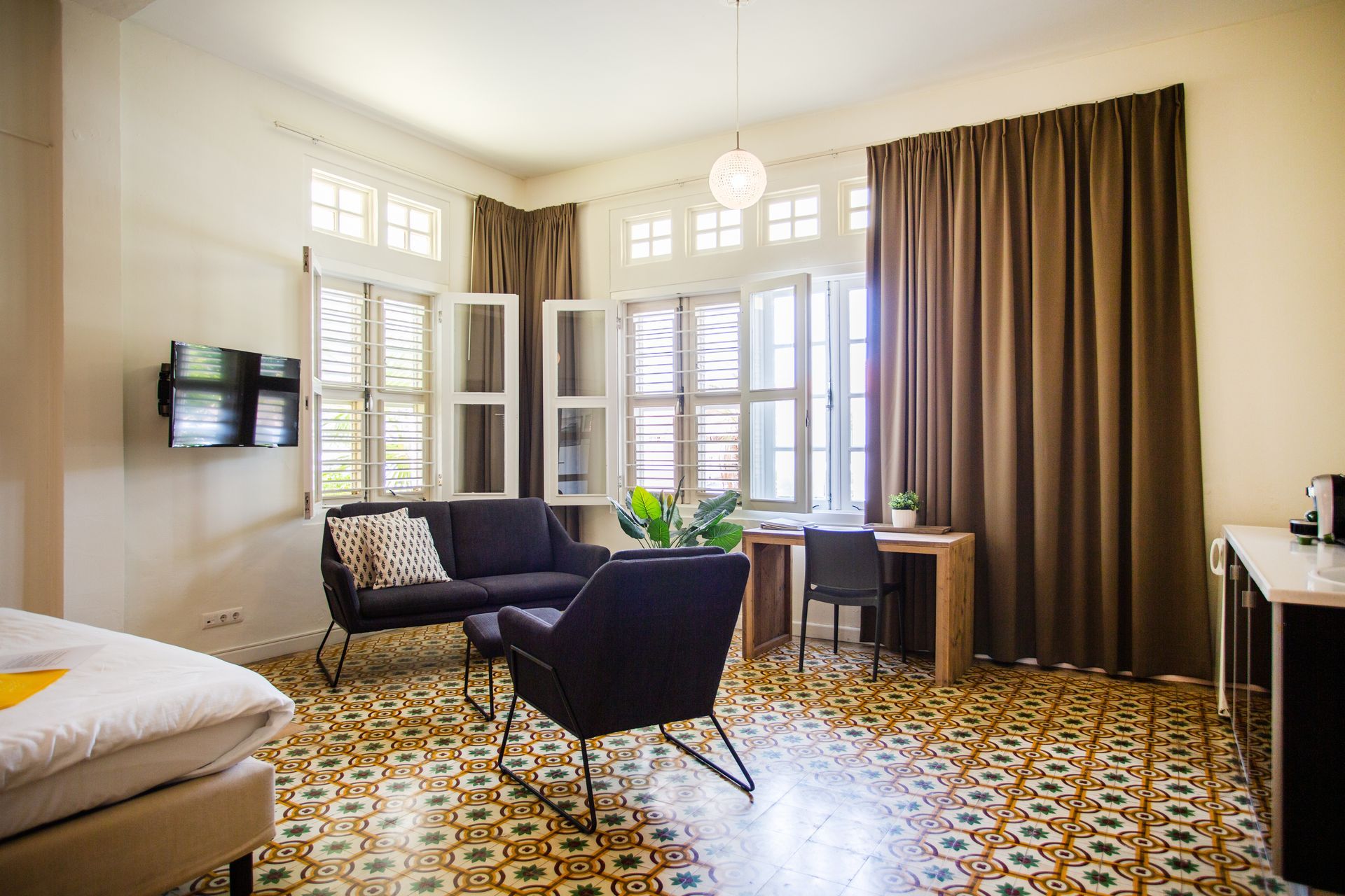 A living room with a couch , chairs , and a desk. t Klooster Hotel Curacao