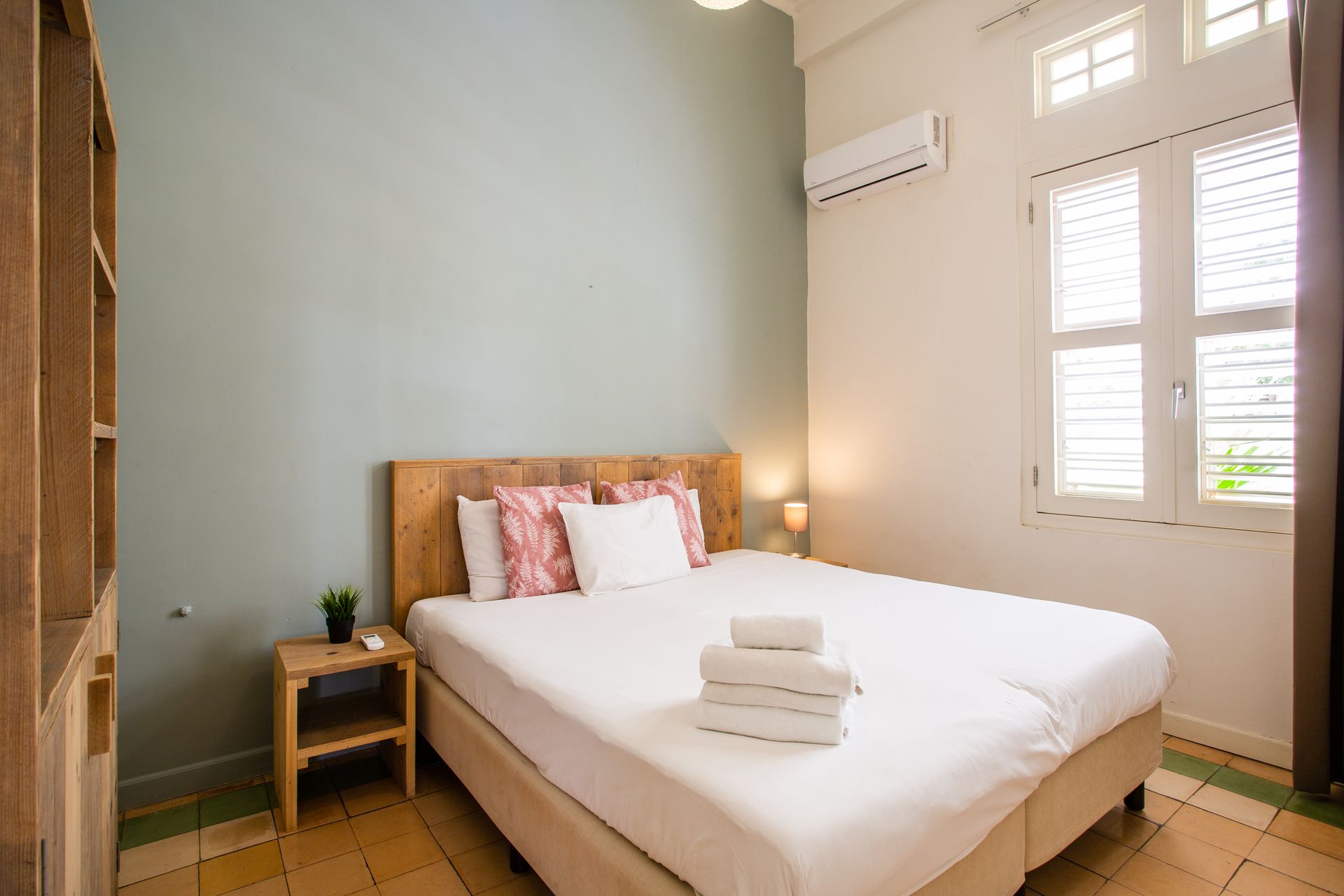 A bedroom with a bed , nightstand , and window.