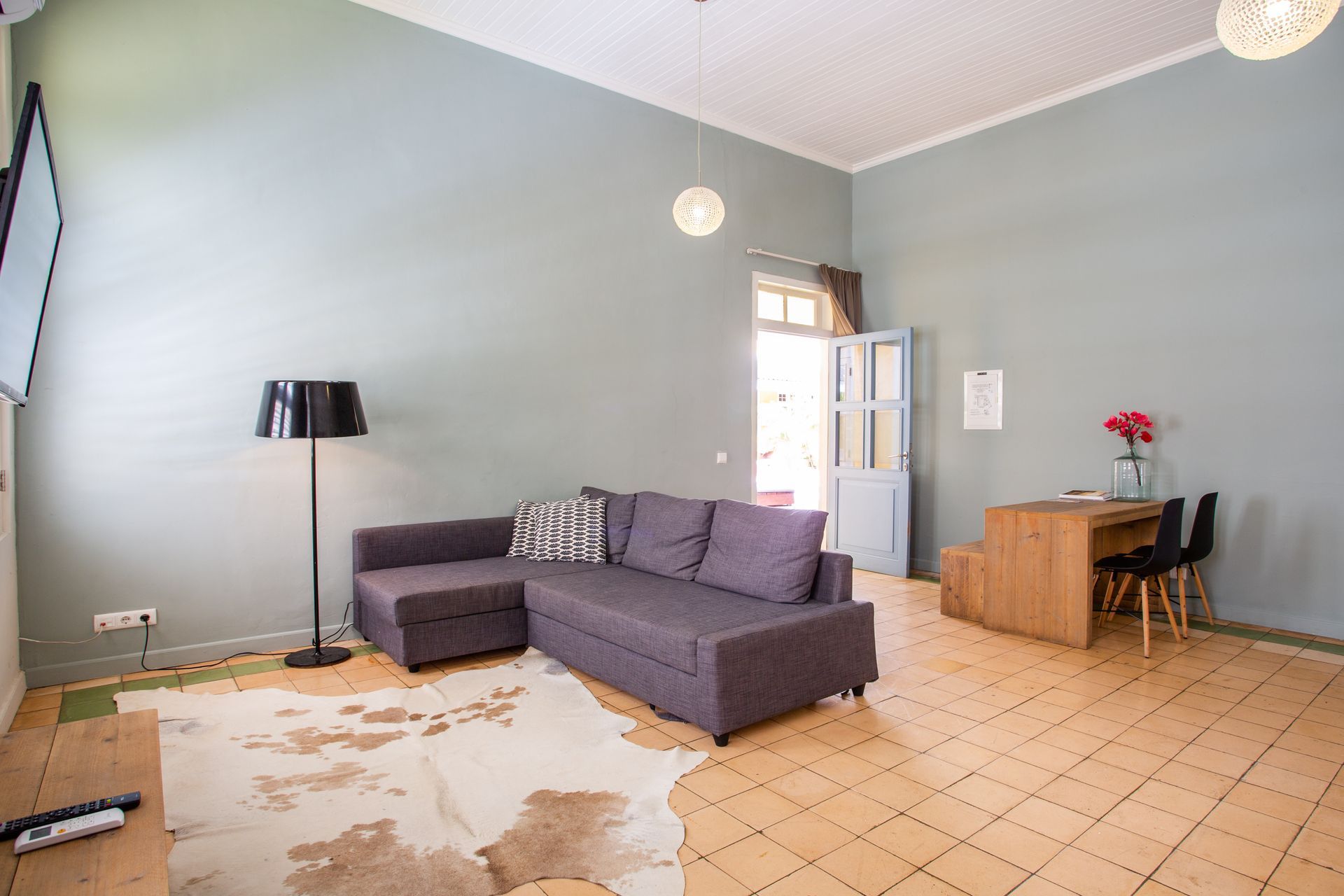 A living room with a couch , rug , table and chairs.