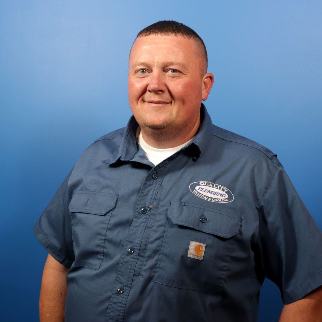 A man wearing a blue shirt with the word carhartt on it