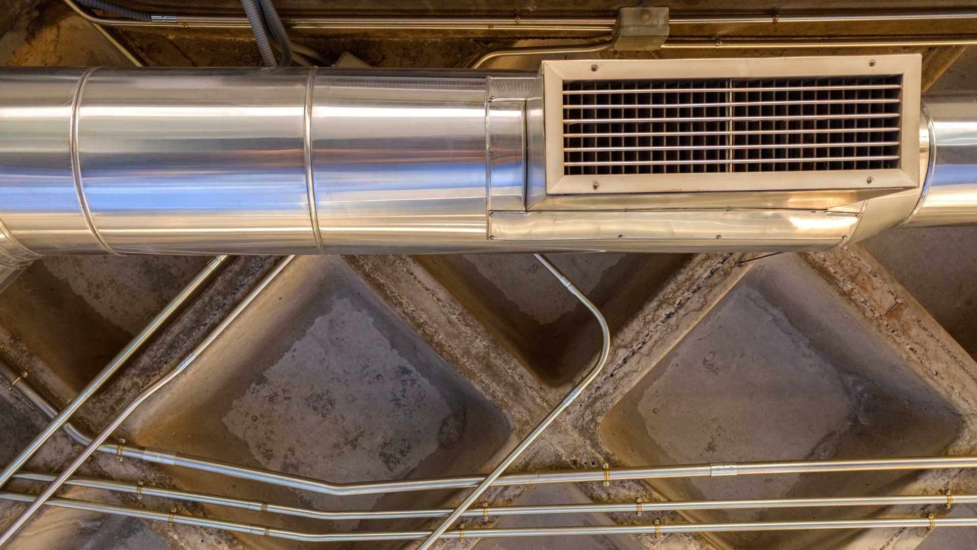 A close up of a metal pipe hanging from the ceiling of a building.