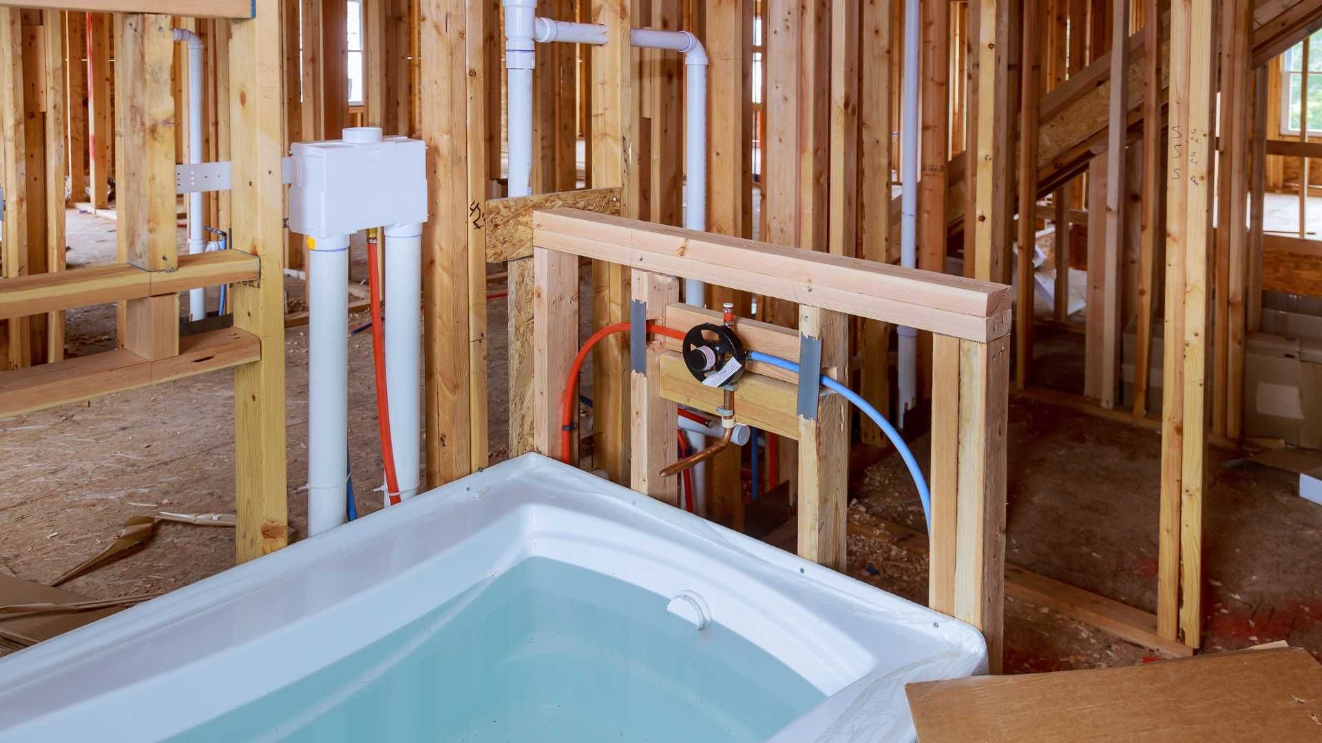 A bathtub is sitting in the middle of a building under construction.