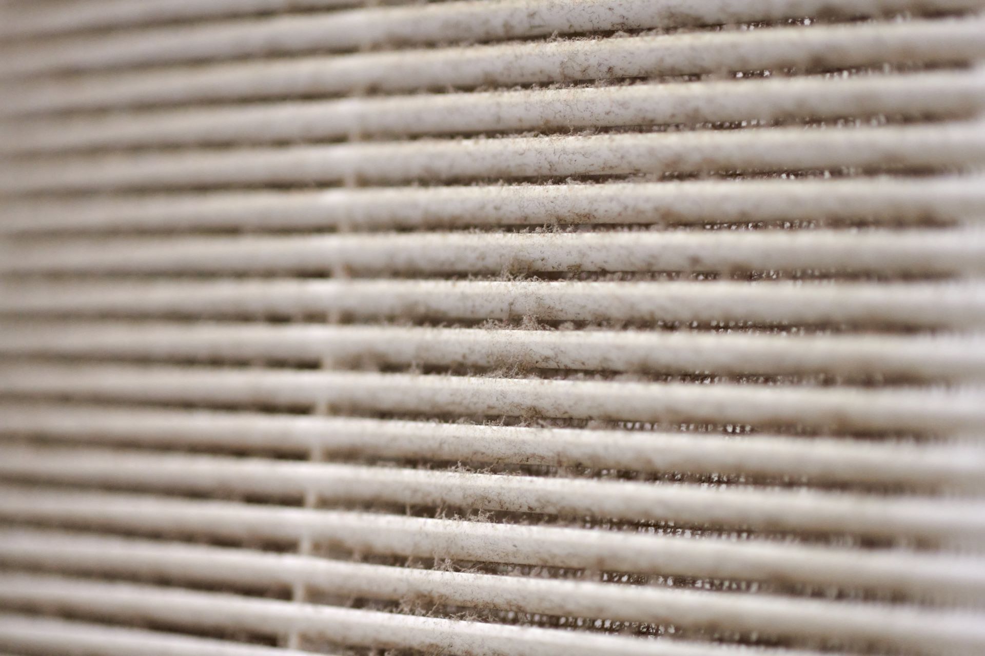 A close up of a dirty air filter with a lot of dust on it.