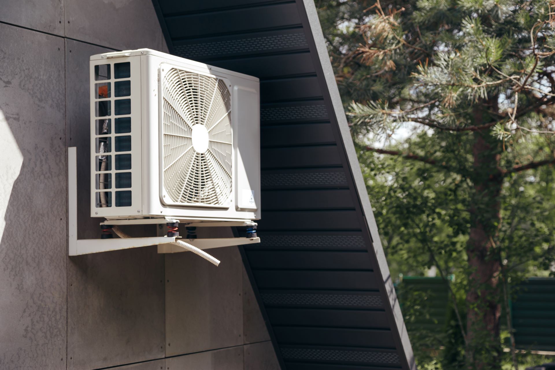 Air conditioning unit mounted on the side of a house.