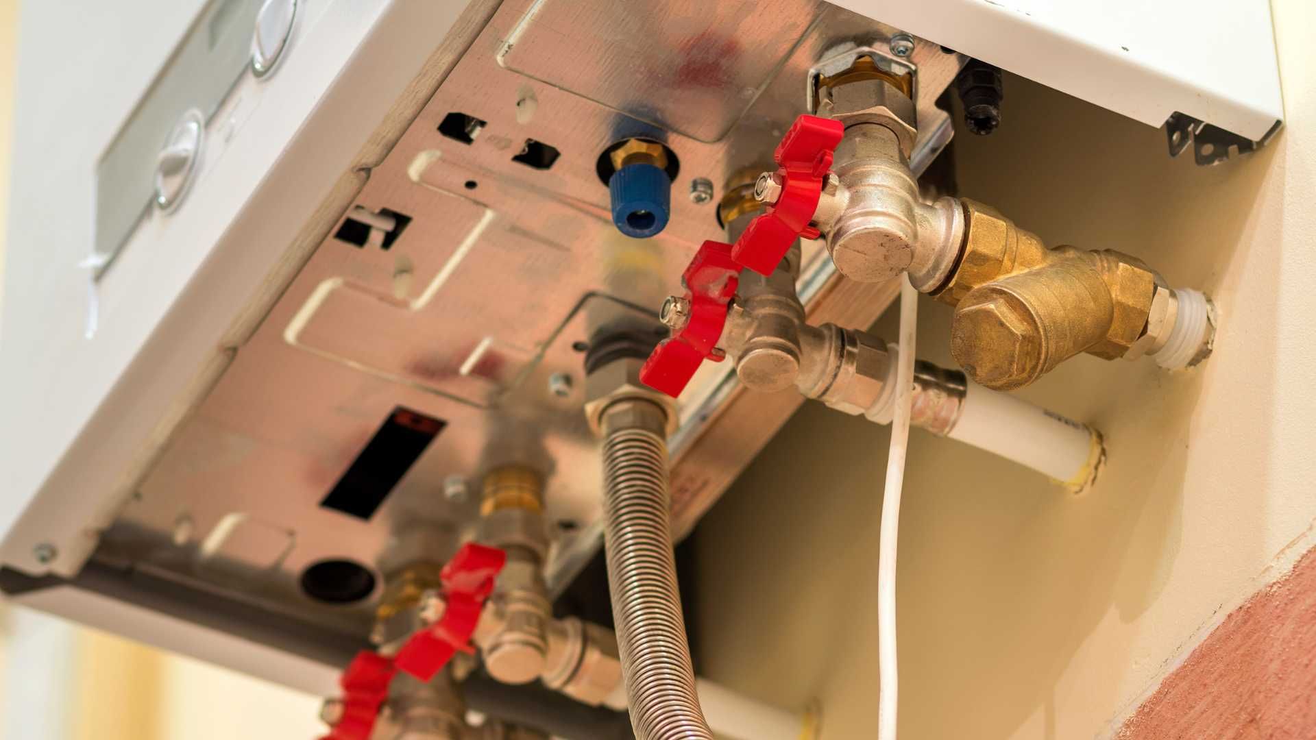 A close up of a boiler with a lot of pipes and valves.