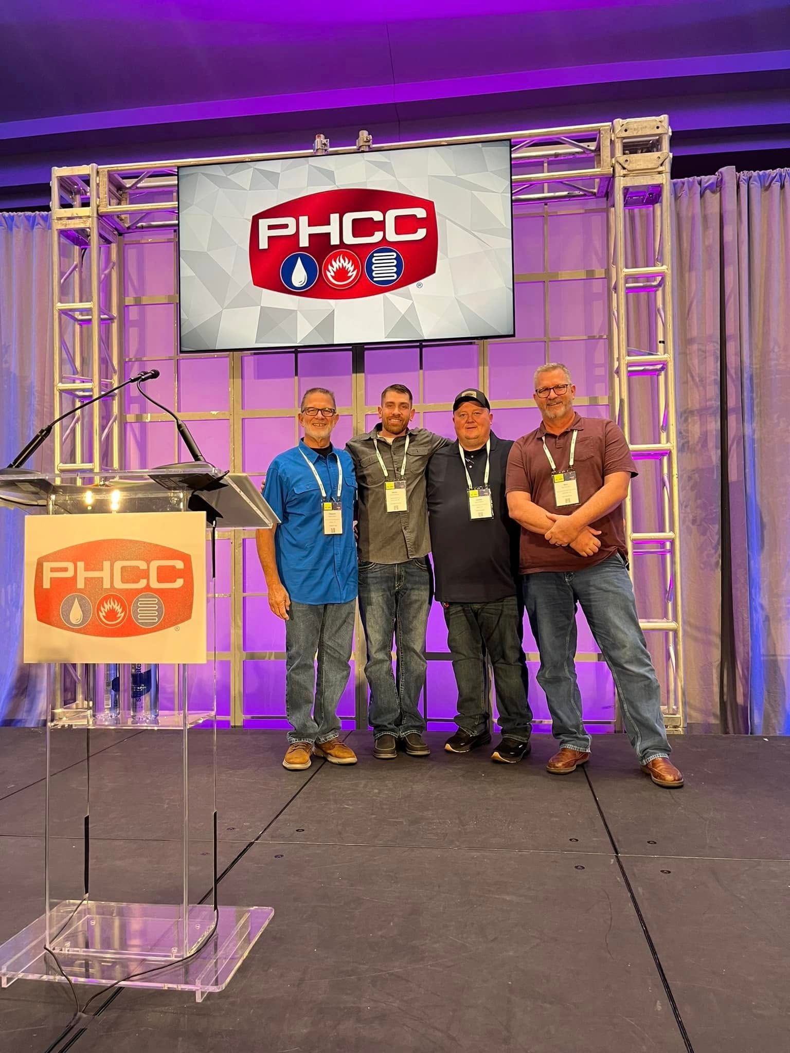 A group of men are posing for a picture on a stage.