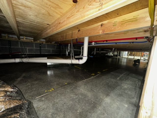 A basement with a lot of pipes coming out of it.