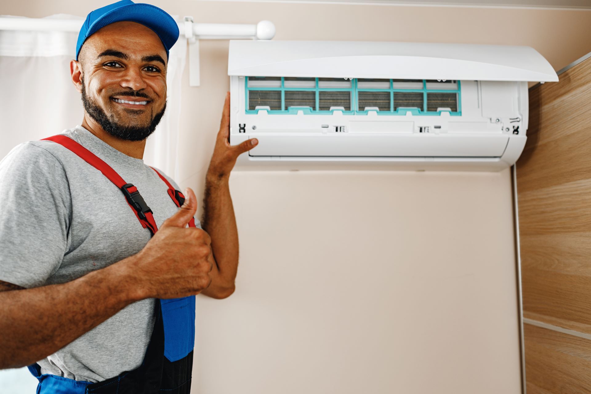 A man is holding an air conditioner and giving a thumbs up.