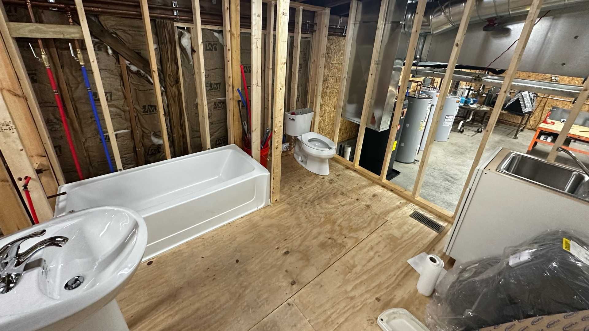 A bathroom under construction with a sink , toilet and bathtub.