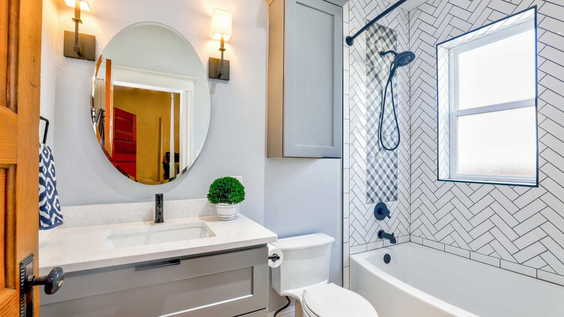 A bathroom with a sink , toilet , bathtub and mirror.