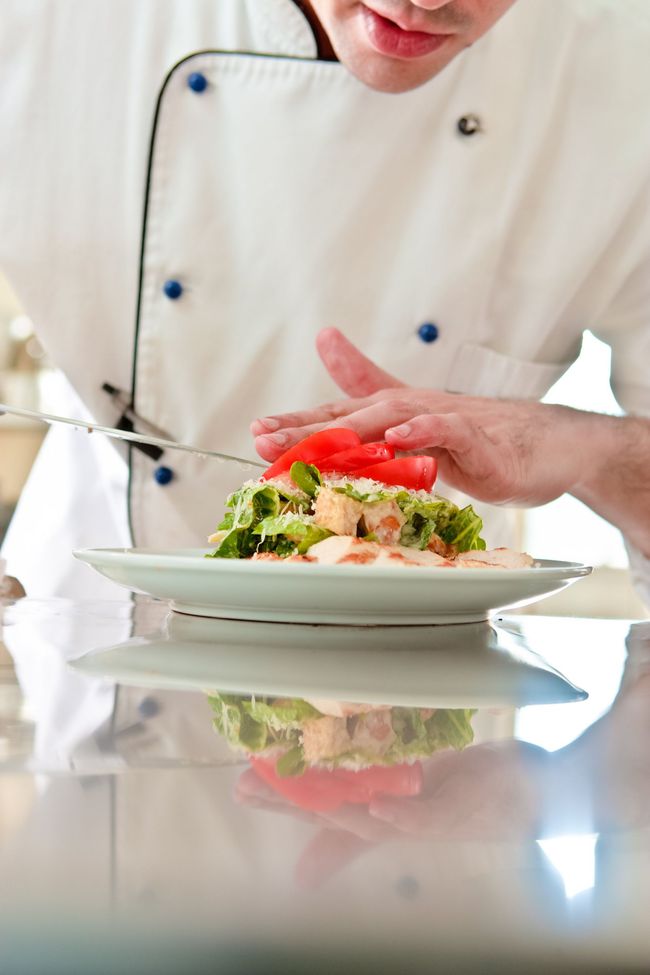 a chef is preparing a salad on a plate