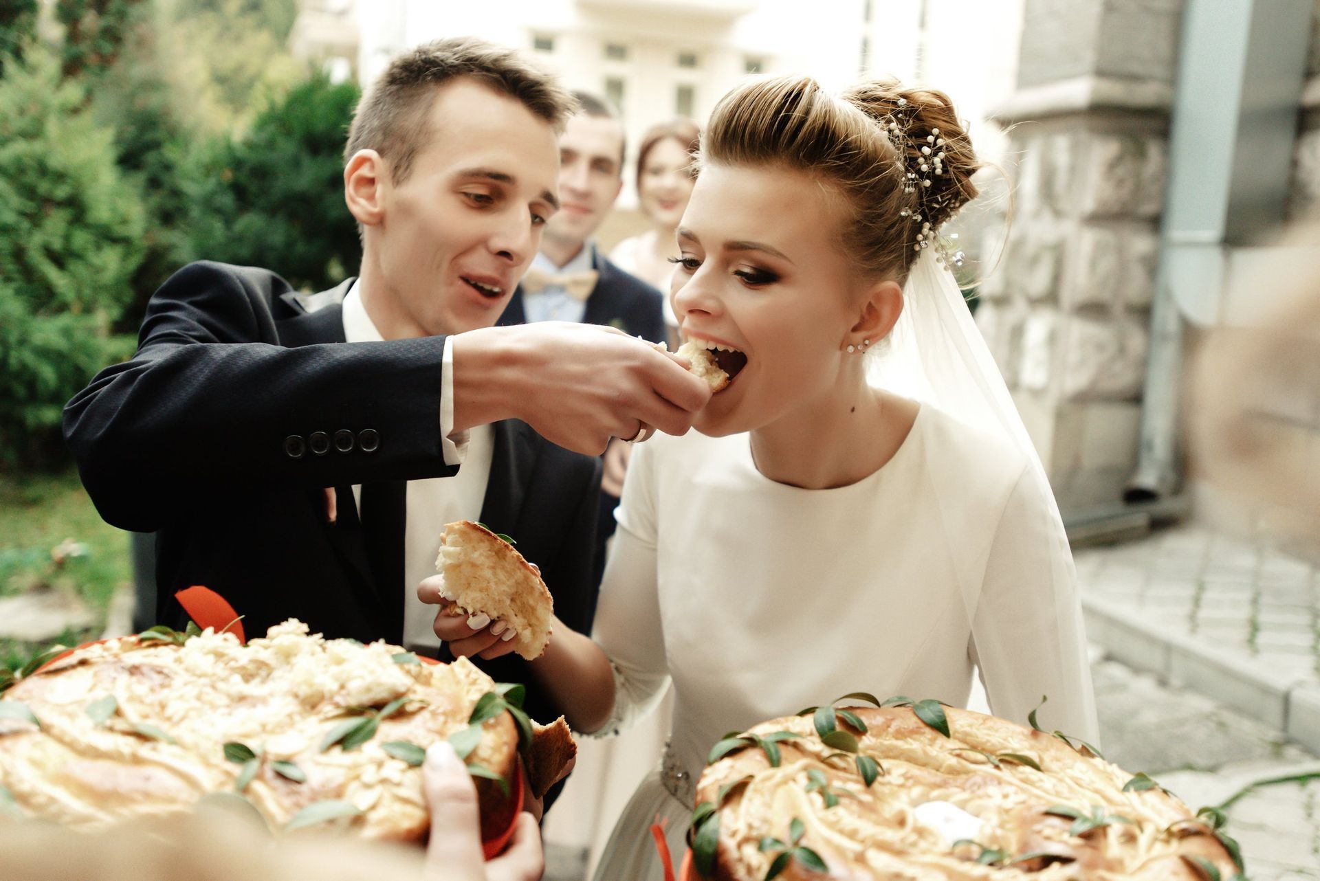 a bride and groom are eating a cake together at their wedding