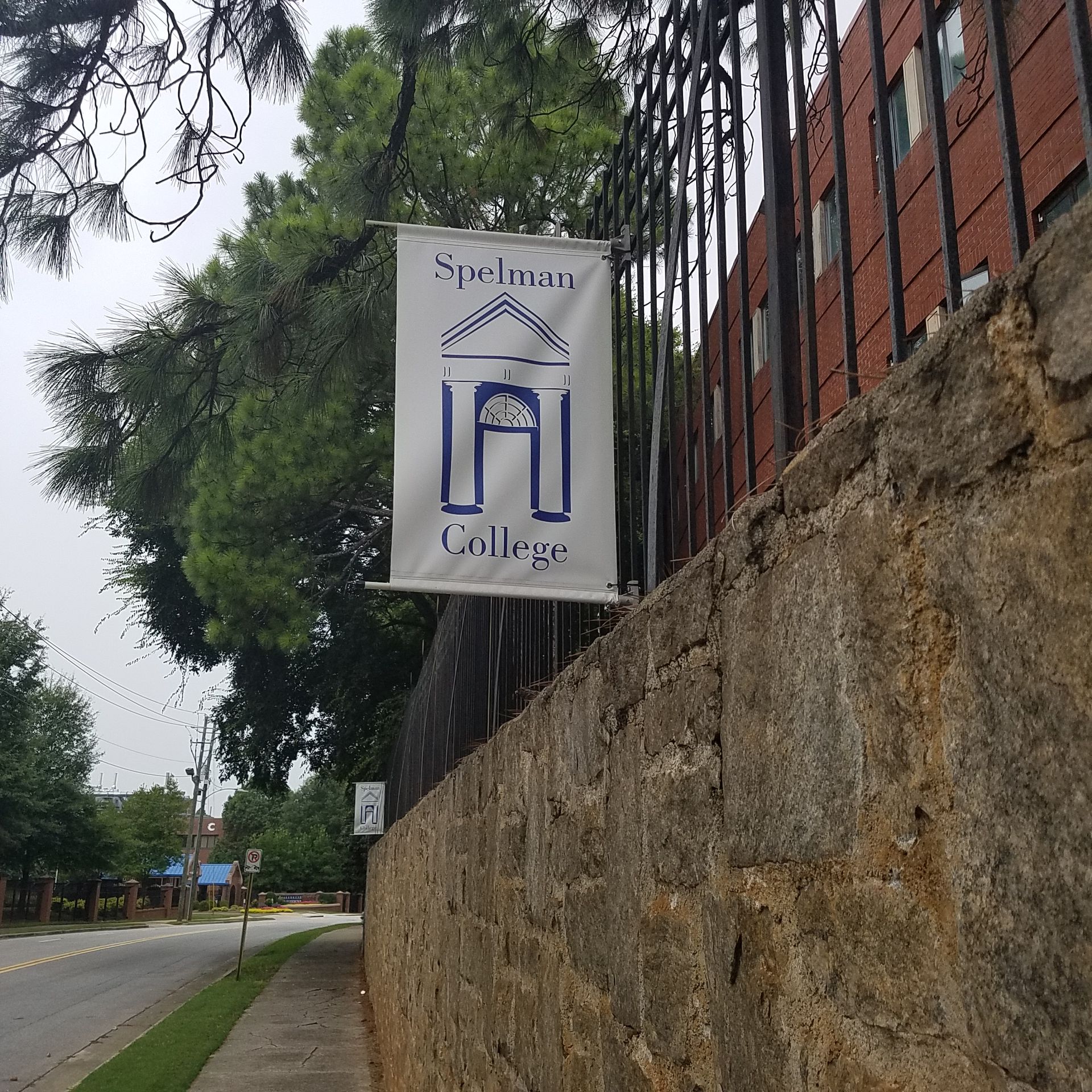 A banner hanging on a stone wall says sanderson college