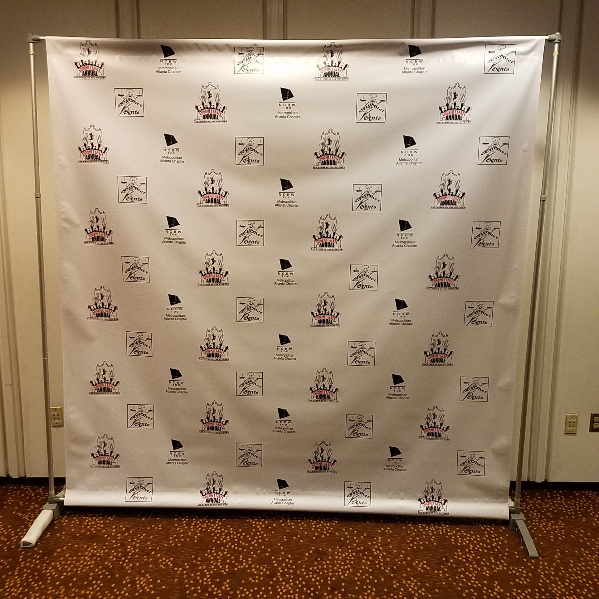 A white backdrop with a pattern of flags and crowns on it