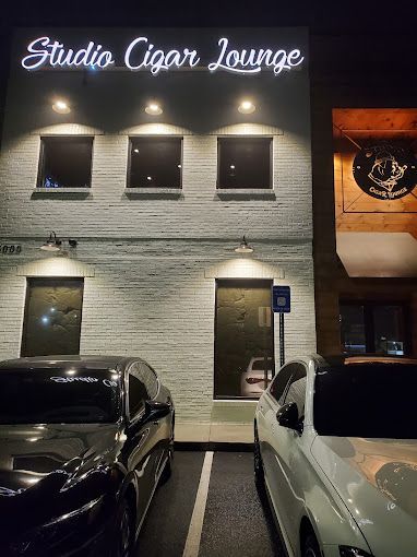 A couple of cars are parked in front of a building.