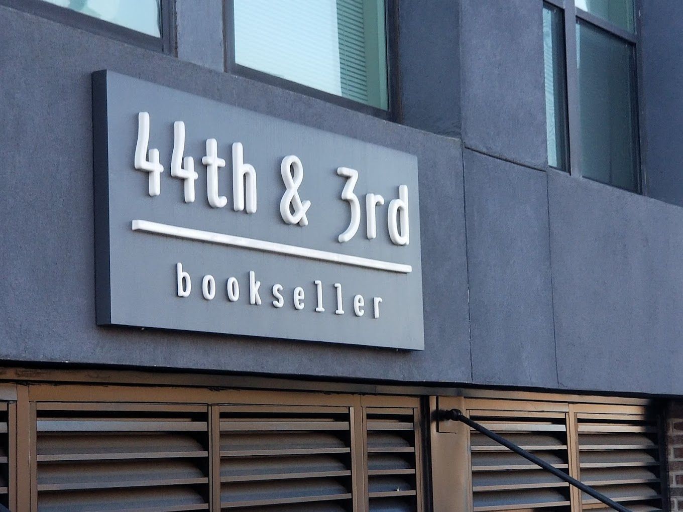 A sign on the side of a building that says 44th & 3rd bookseller