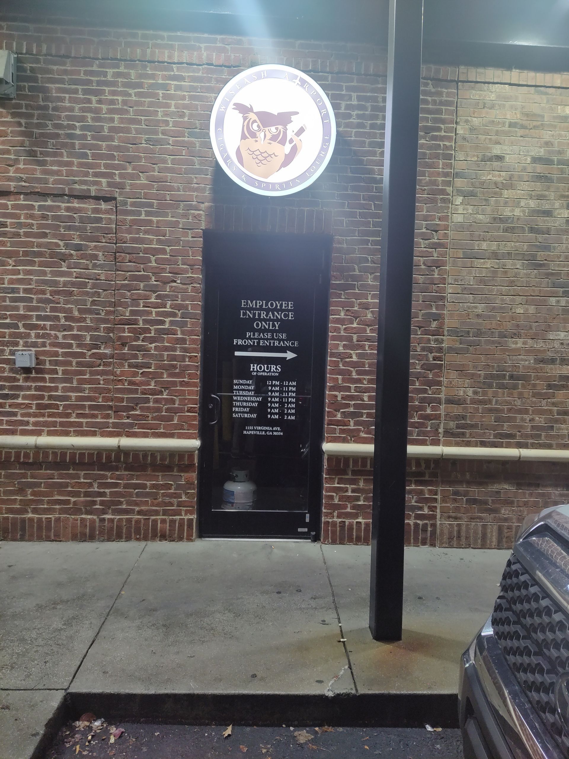 A brick building with a sign that has an owl on it