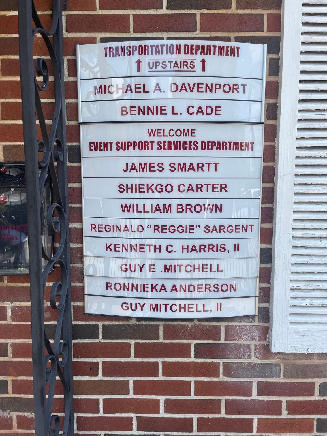 A sign on a brick wall that says transport station department upstairs