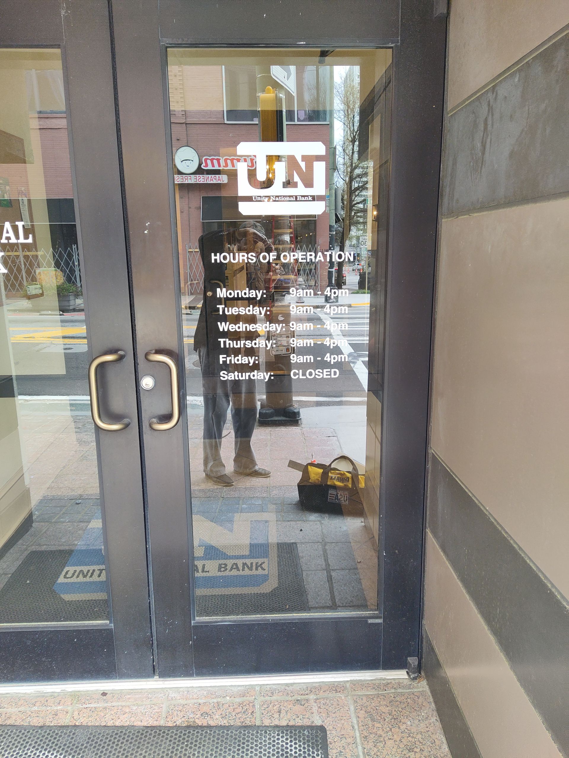 A person is standing in front of a door that says un on it.