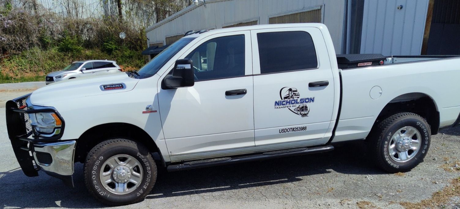 A white pickup truck is parked in front of a building.