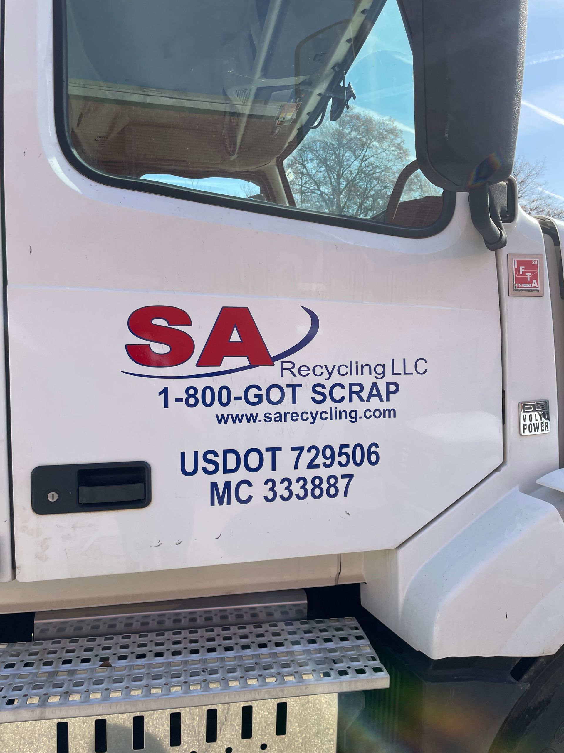 A white truck with a sticker on the door that says sa recycling llc
