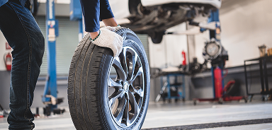 Technician with wheel to install | Seehorn Tire