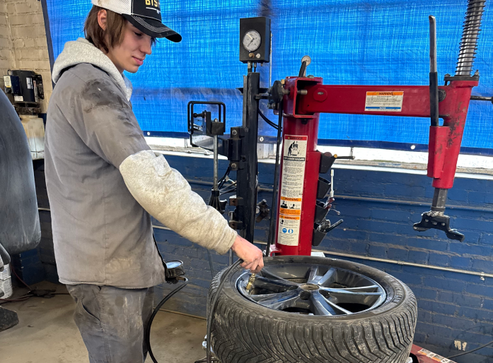 Technician examining wheel in garage | Seehorn Tire