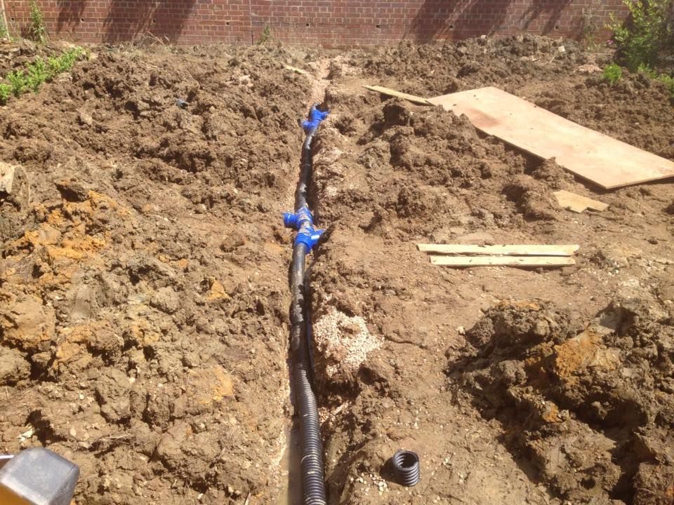 garden drainage pipes being laid in channels