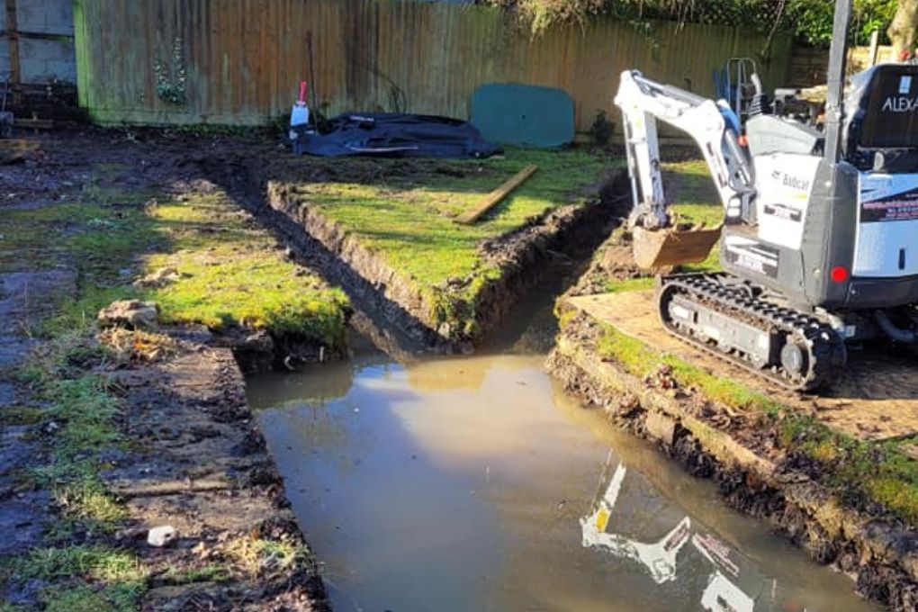 DNA Landscapes French drainage trenches being installed in clay soil in Bulkington