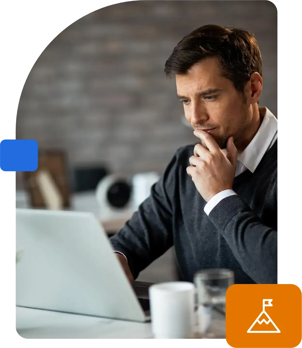 Um homem está sentado em uma mesa usando um laptop.