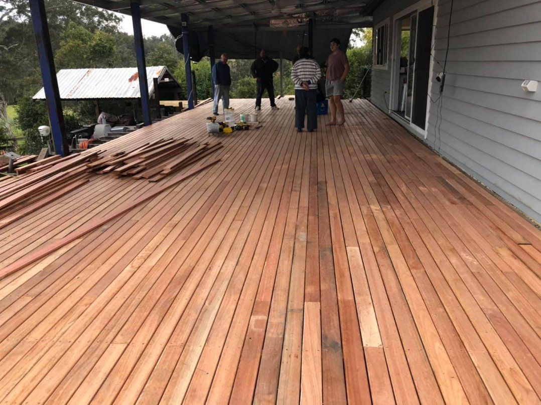 A Group of People Are Standing on A Large Wooden Deck — Alcando Renovations & Maintenance In Forster, NSW