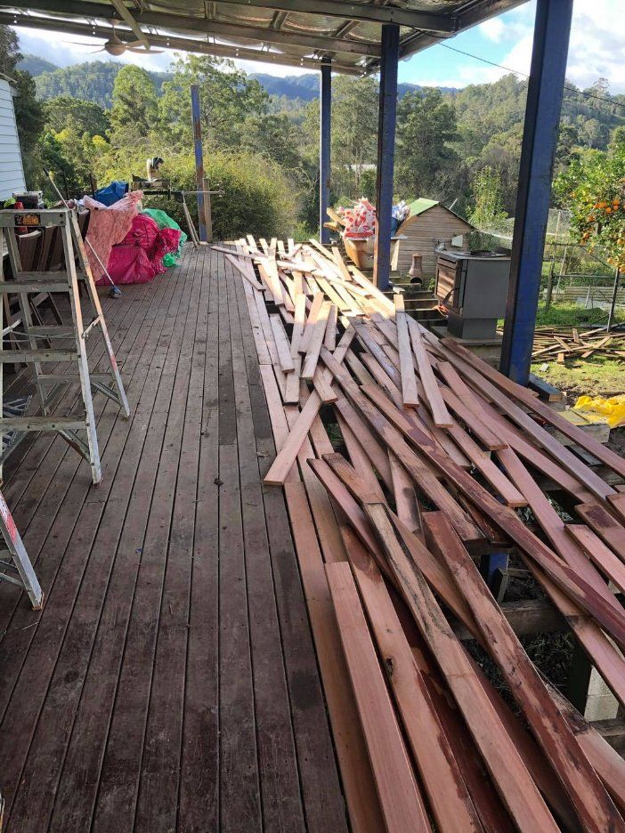 A Pile of Wood Is Sitting on Top of A Wooden Deck — Alcando Renovations & Maintenance In Taree, NSW