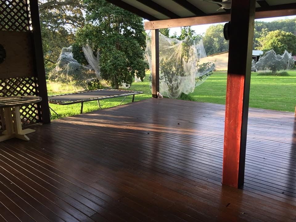 A Wooden Deck with A Red Pole in The Middle — Alcando Renovations & Maintenance In Old Bar, NSW