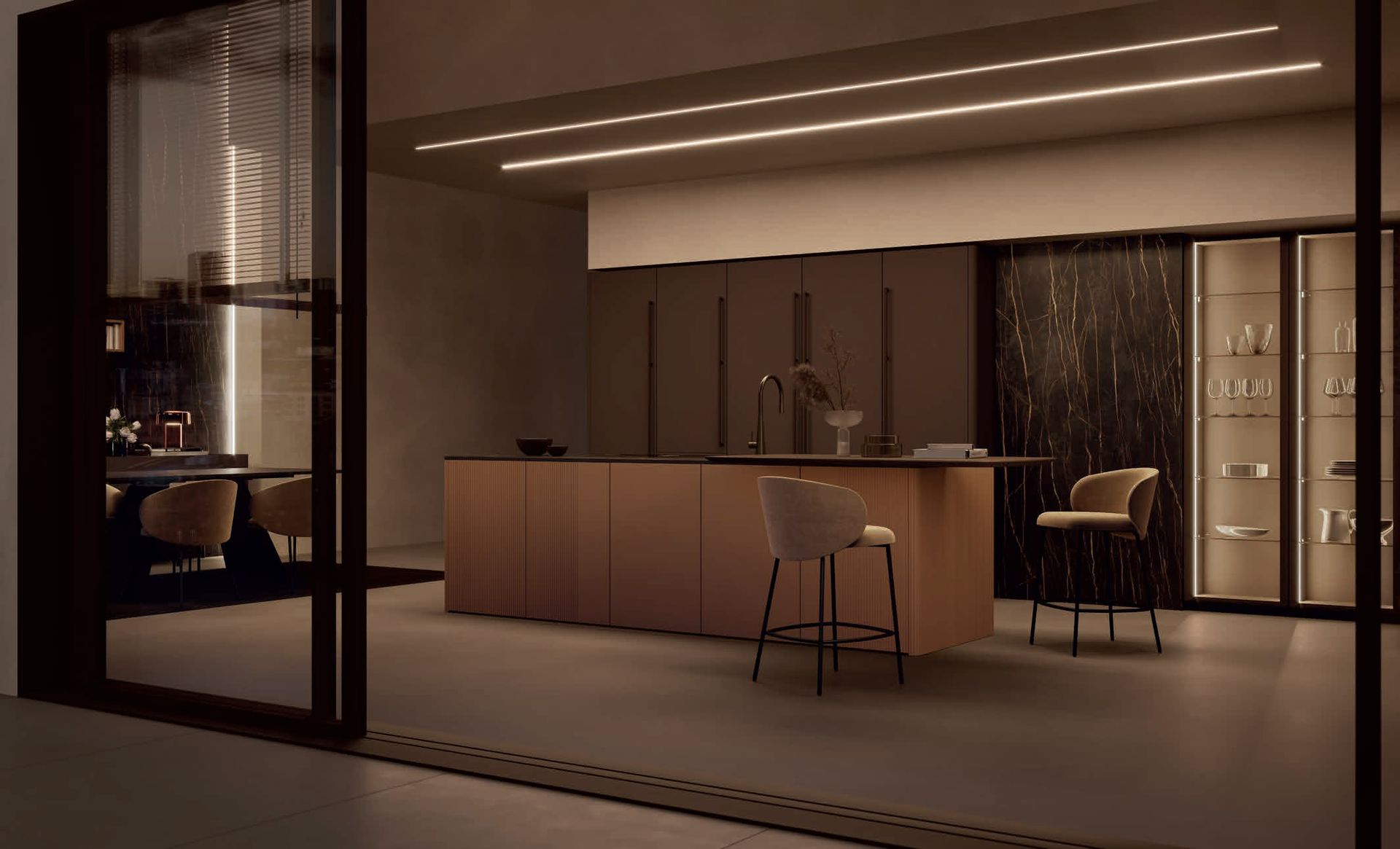 Cucina moderna con isola in legno, mobili e illuminazione calda. Porte scorrevoli si aprono sulla zona pranzo.