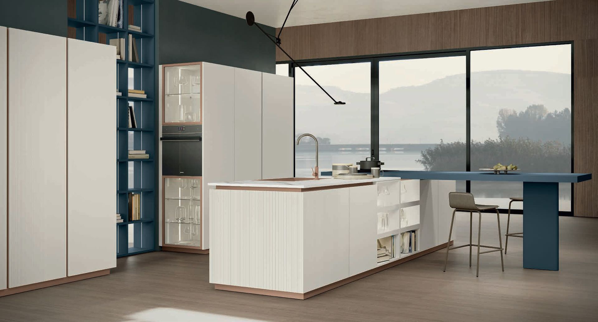 Cucina moderna con mobili bianchi, dettagli blu, isola con posti a sedere e ampie finestre.