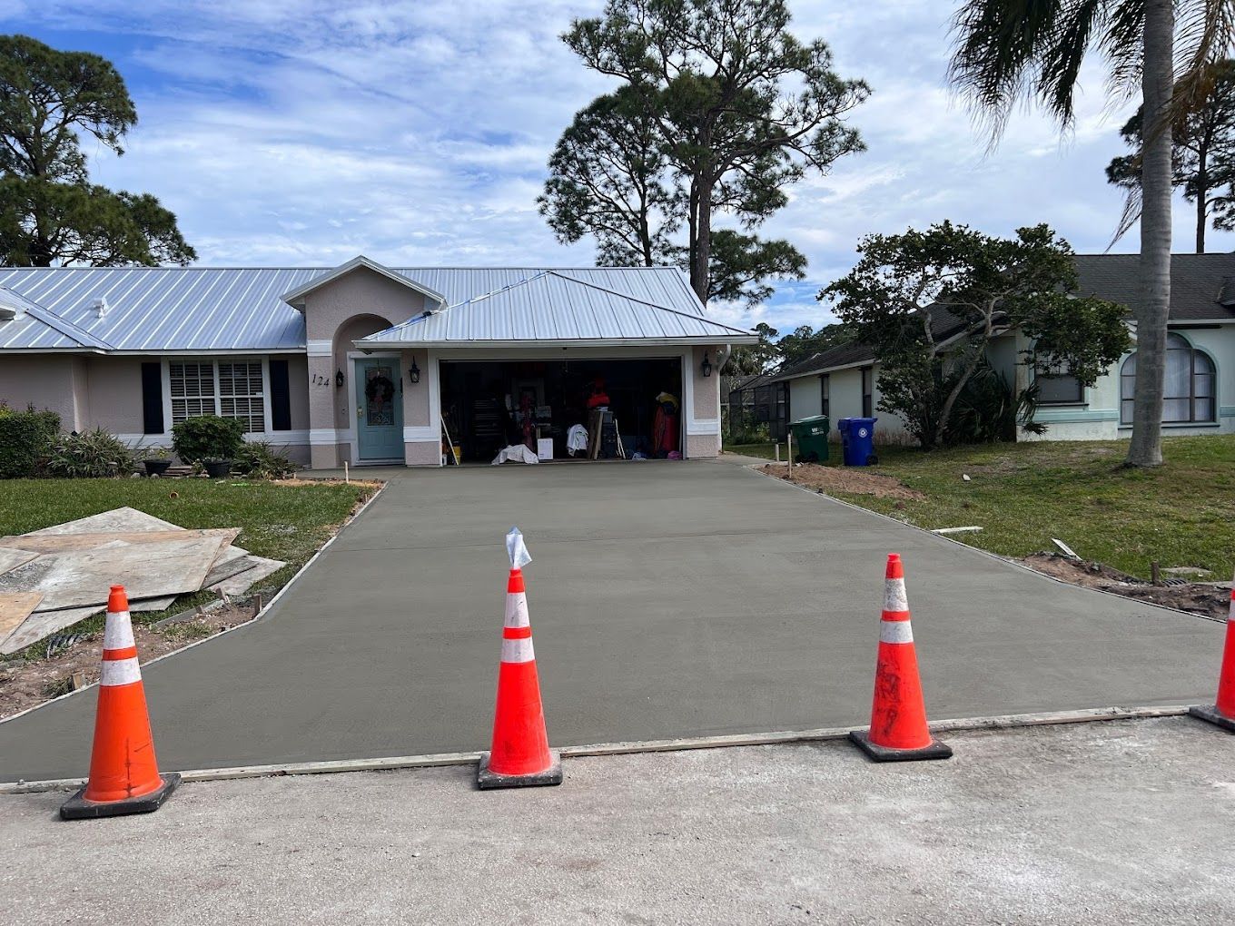 A concrete driveway is being built in front of a house.