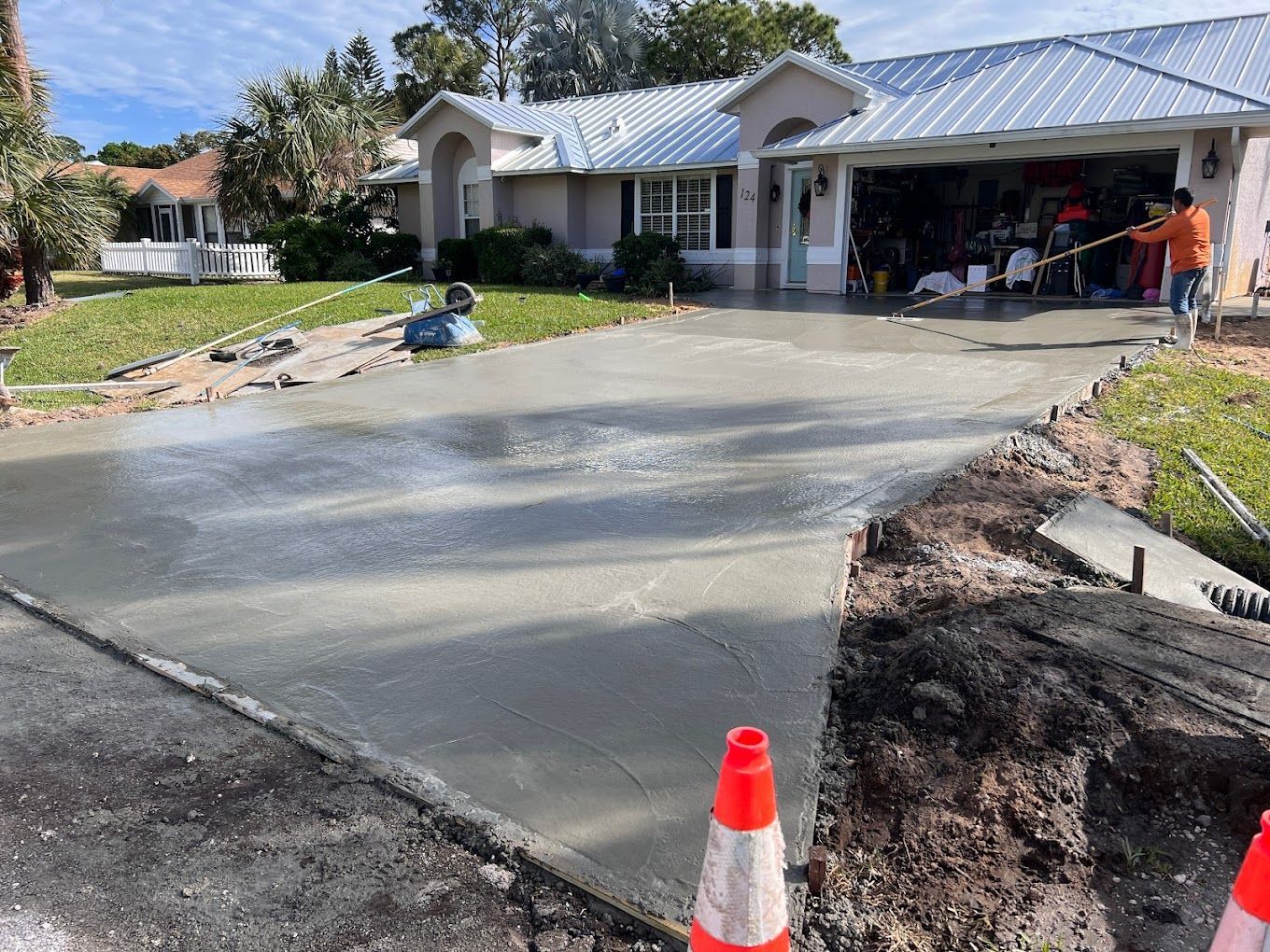 A concrete driveway is being built in front of a house.