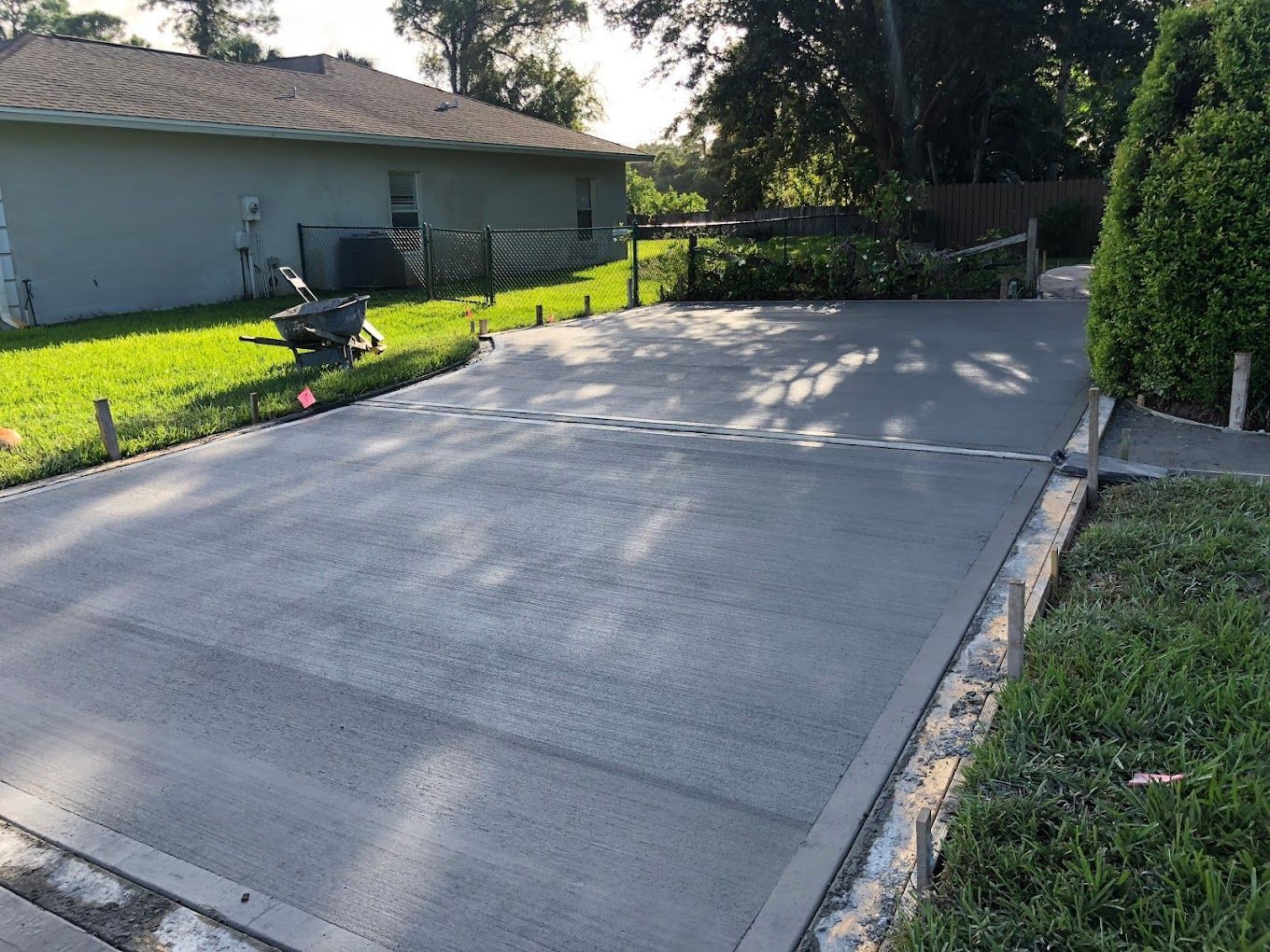 A concrete driveway is being built in front of a house.