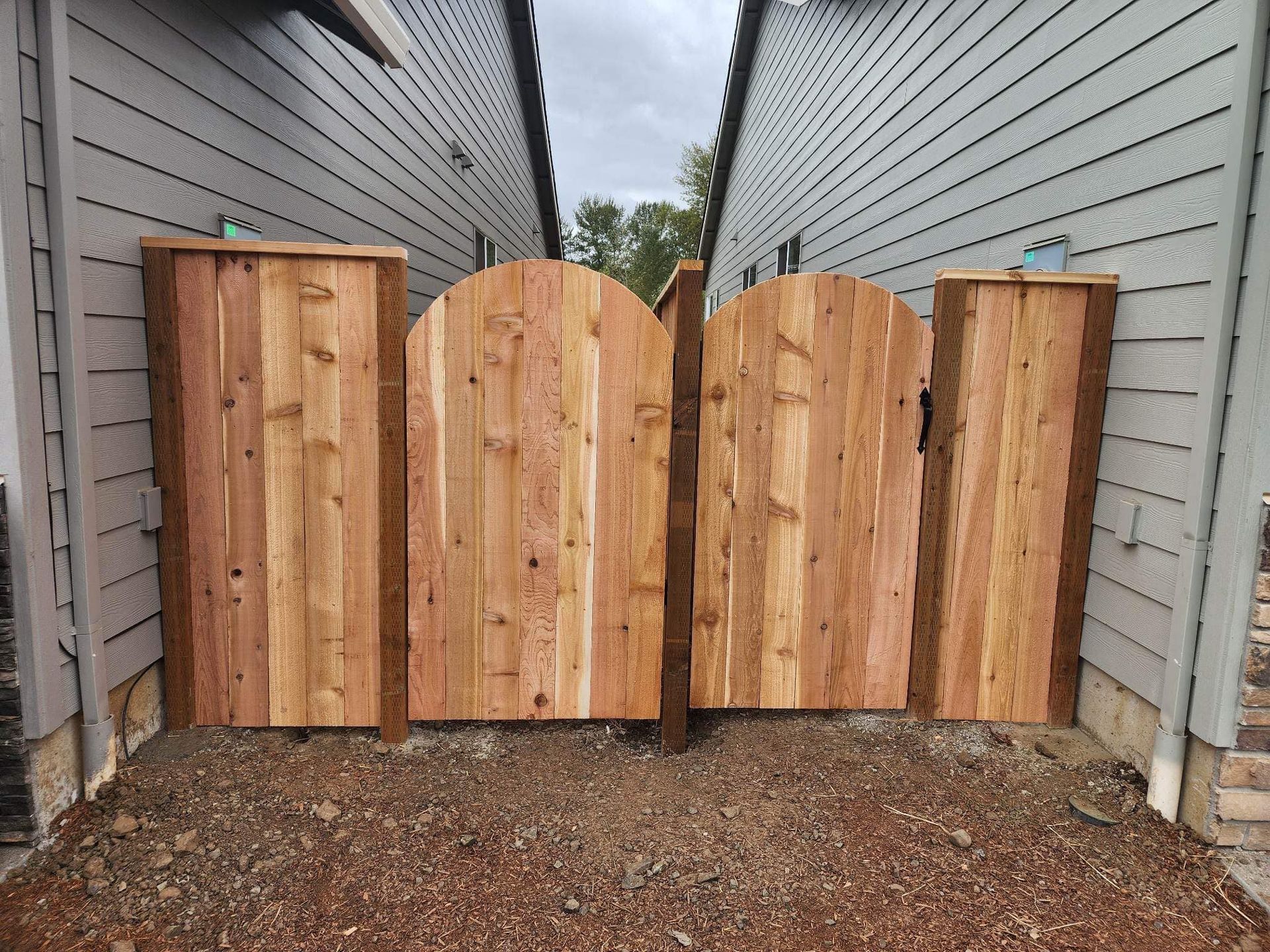 Wooden fence panels forming a privacy barrier between two narrow house walls