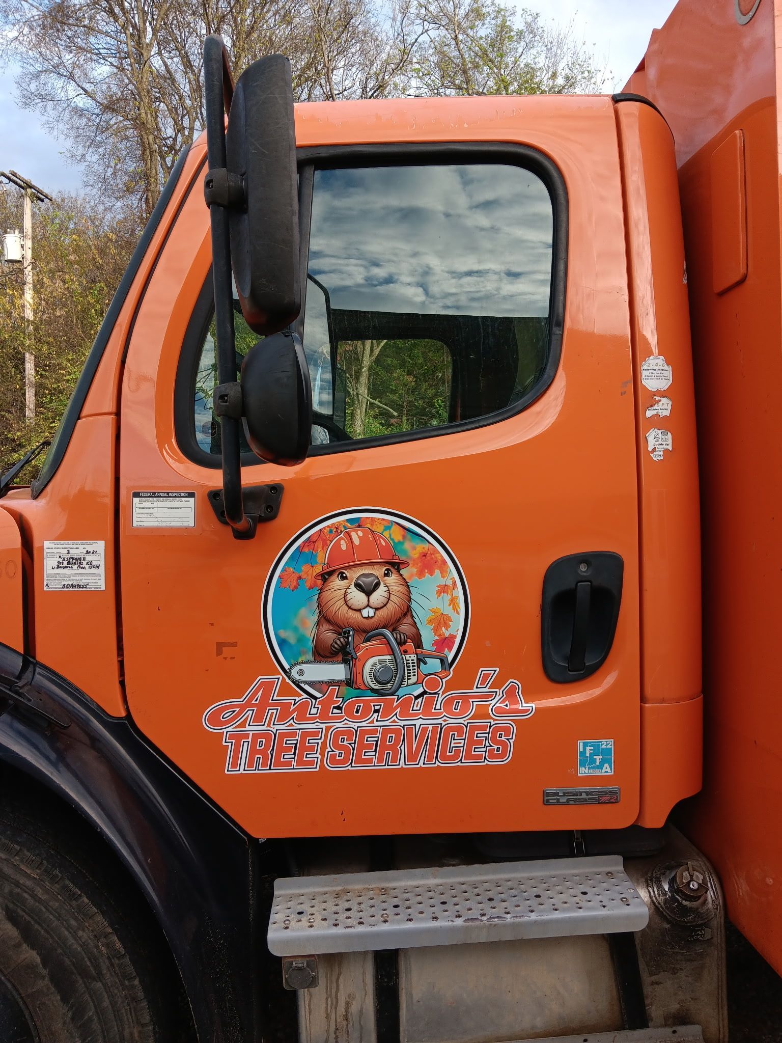 An orange truck with a sticker of a teddy bear on it