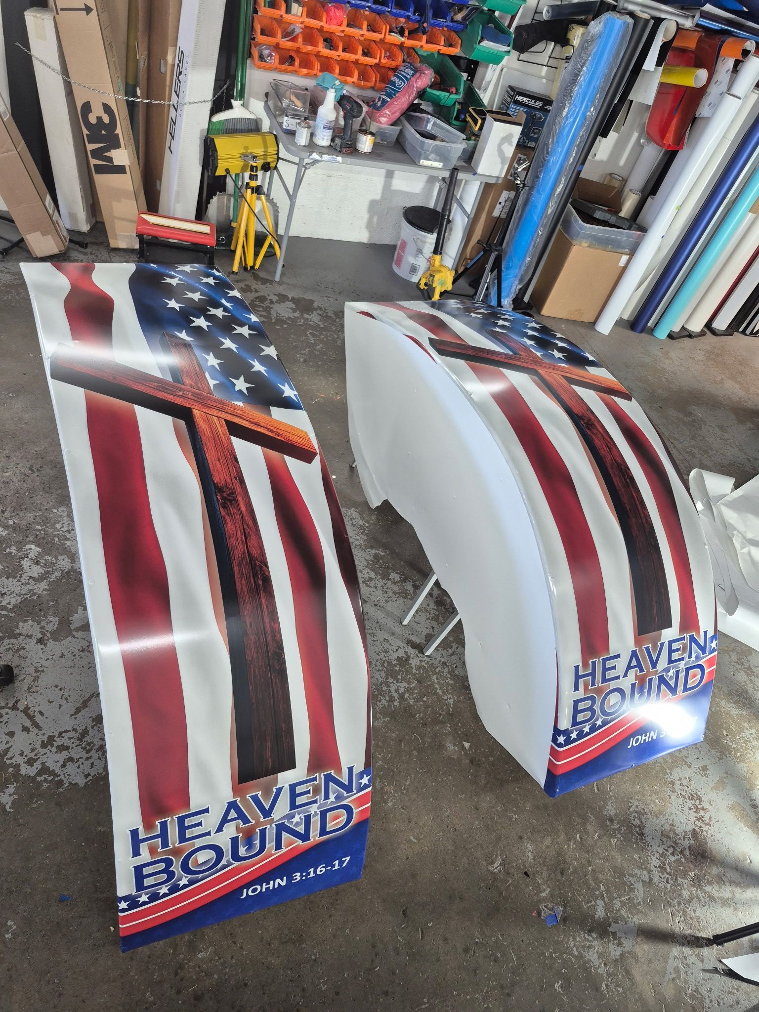 Two curved white panels with an American flag and a cross design, text reads 