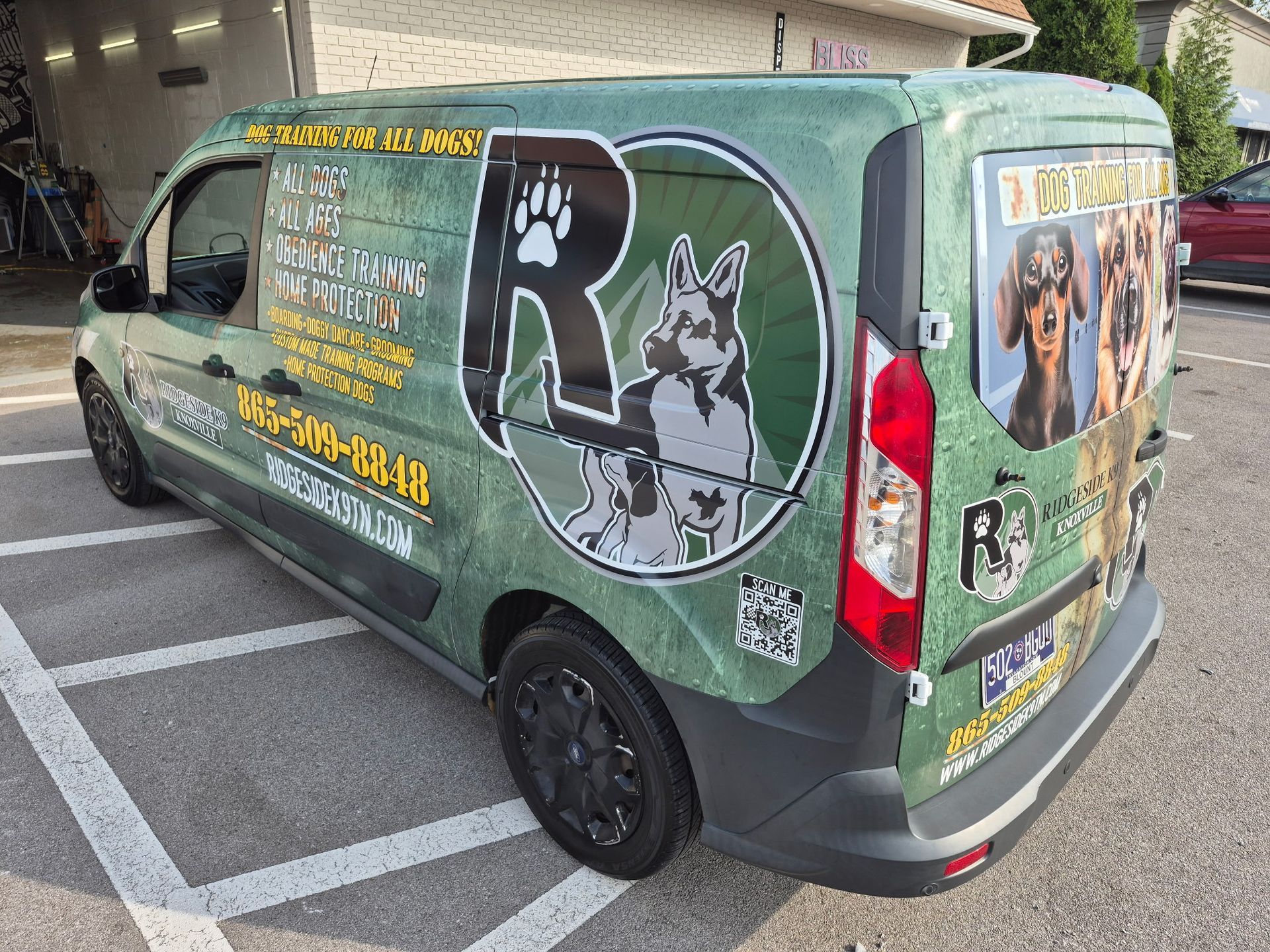 Green van with dog training graphics; parked in a parking lot. Features logo with dog and paw prints.
