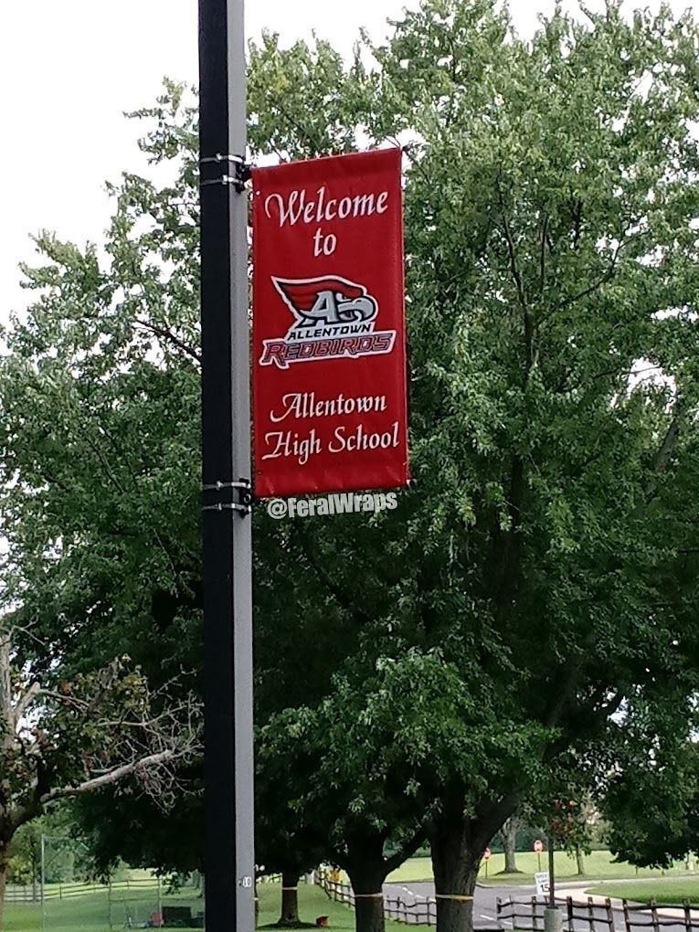 A red banner on a pole that says welcome to milton high school