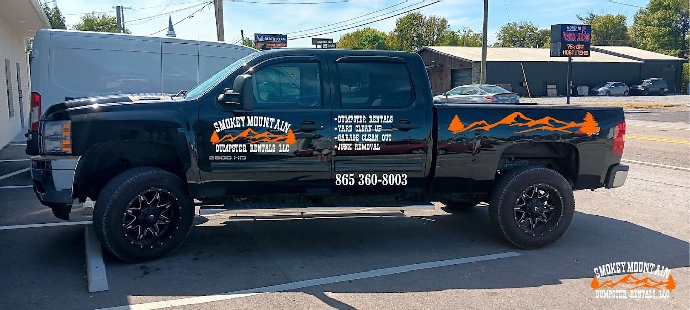 A black truck is parked in a parking lot.