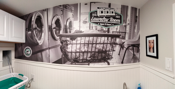 A laundry room with a picture of a laundromat on the wall.