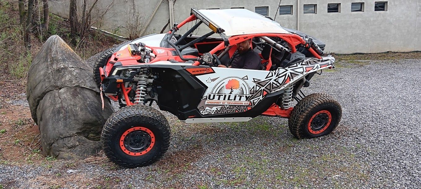 A red and white atv is parked in a gravel lot.