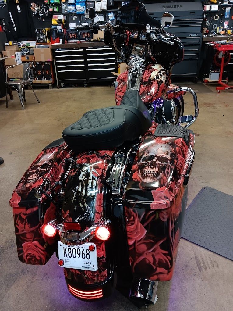 A harley davidson motorcycle with skulls and roses painted on it