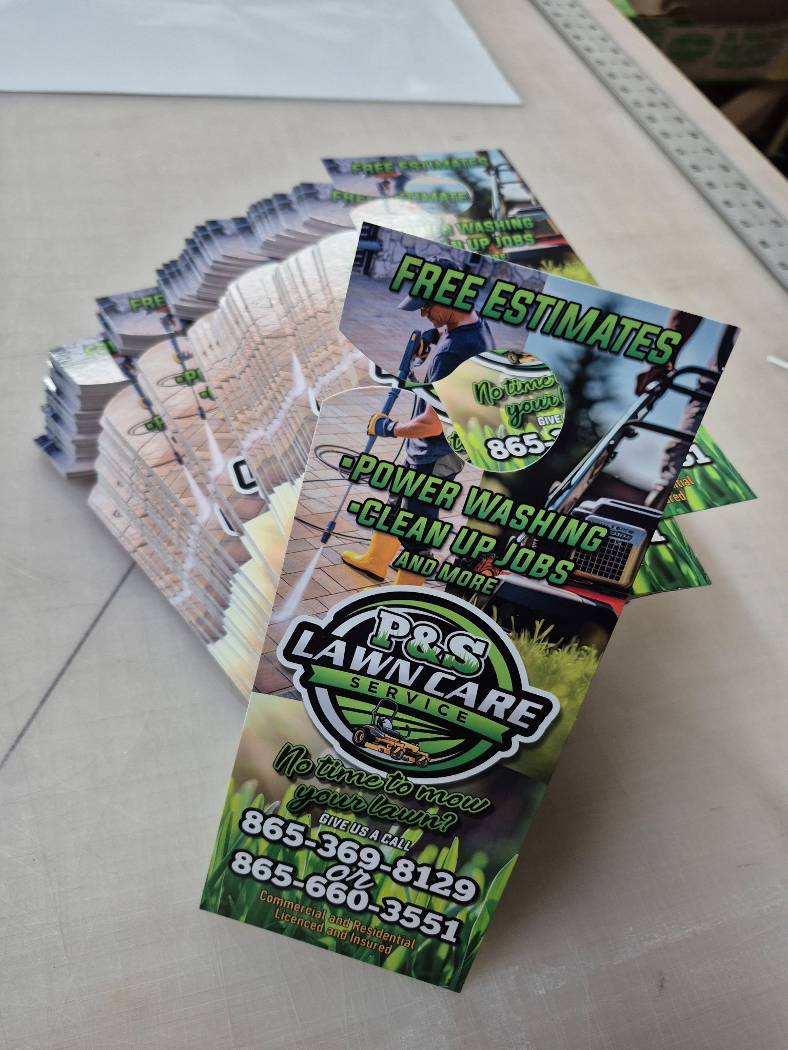 A stack of lawn care business cards on a table