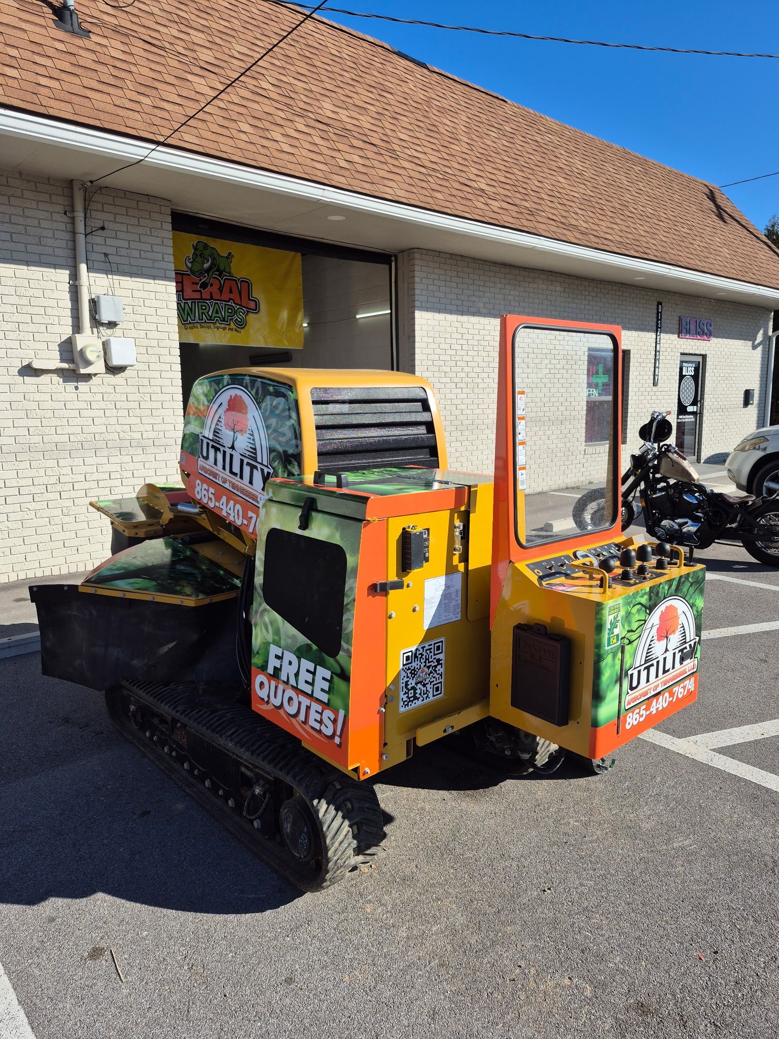 A small yellow and orange vehicle is parked in front of a building.