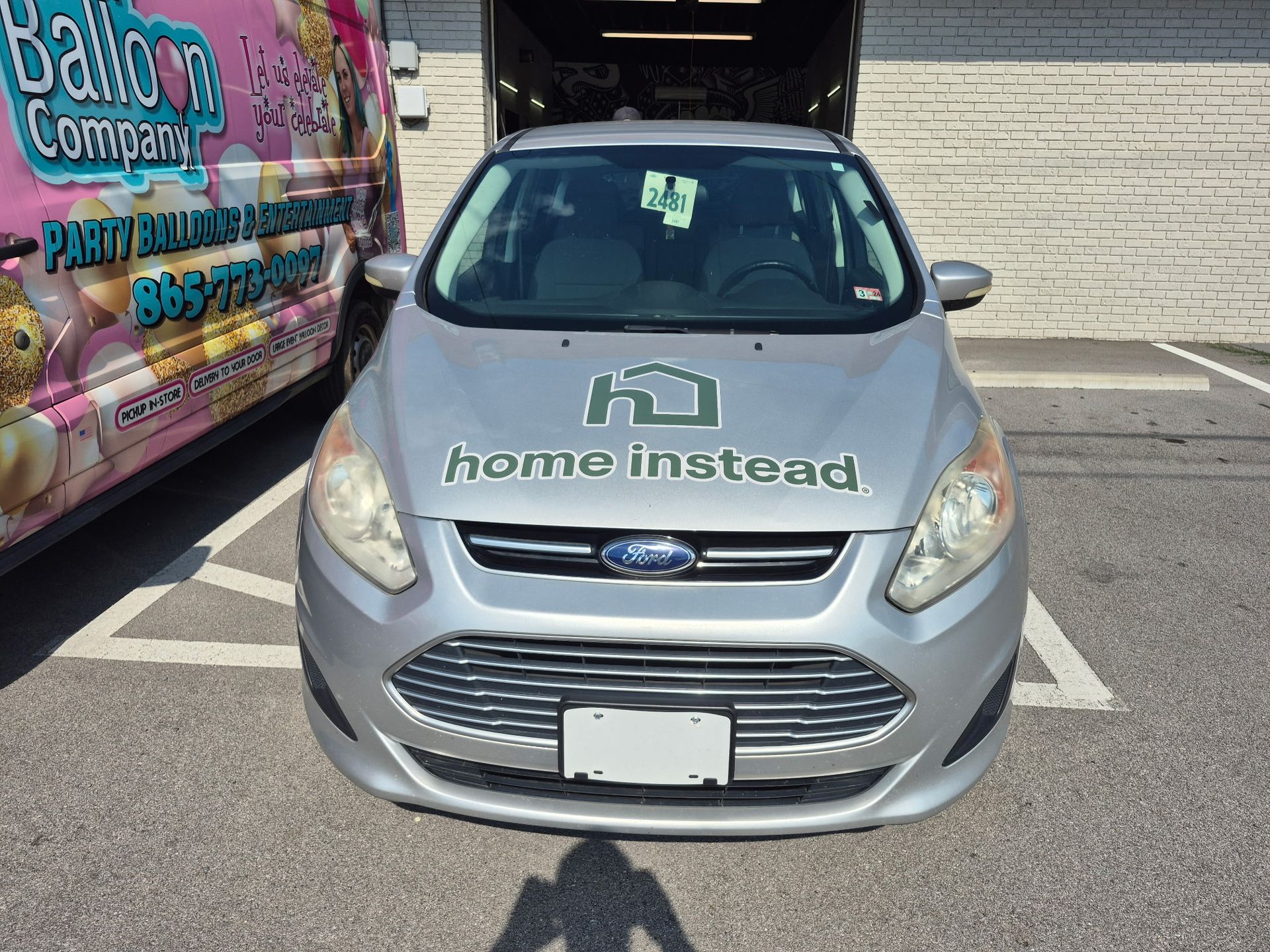 A silver ford car with the word home instead on the hood